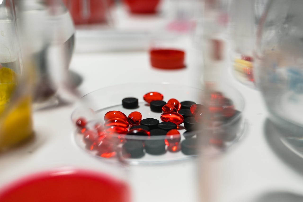 gallery-06 Close-up view of red and black pills on a lab table with blurred background.